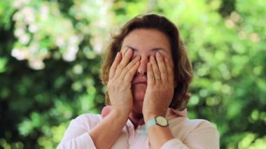 Tired woman rubbing eyes. Candid casual Older woman with hands in face feeling exhausted