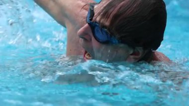 Senior man at the pool emerging from underwater