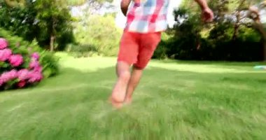 Infant toddler boy running outdoors in backyard garden