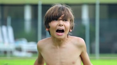 Cute adorable young boy yelling from the top of his lungs outside, funny and cute