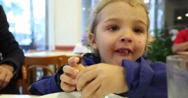 Little boy eating hot dog sausage