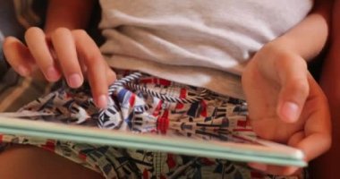 Child hands touching tablet screen