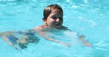 Young boy swimming at the pool