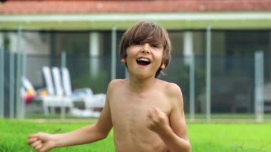 Young boy chest-beating, screaming and roaring to camera, feeling happy smiling and laughing