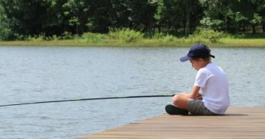 Child boy fishing at lake in outdoor activity