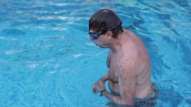 Senior man swimming at the pool. Older person exercising cardio