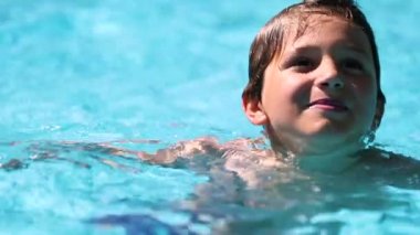 Young boy at the swimming pool water, candid child at the pool
