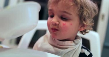 Feeding soup to adorable cute blonde baby boy