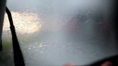 Windshield wipers in slow-motion clearing rain