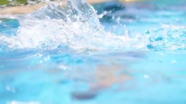 Happy child going underwater inside swimming pool water