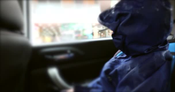 Мальчик Смотрит Окно Машины Дождевом Пальто Мальчик Сидит Заднем Сиденье — стоковое видео