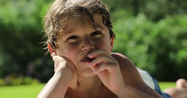 Kid Laid Grass Portrait Eating Cookie — Stock video