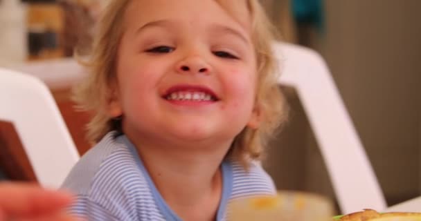 Ευτυχισμένο Νήπιο Αγοράκι Που Χαμογελάει Καθισμένο Στο Τραπέζι Του Πρωινού — Αρχείο Βίντεο