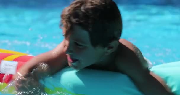 プールで楽しんでいるインフレータブルマットレスの上の子供 — ストック動画