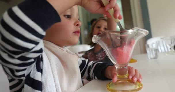 幼児はスプーンでアイスクリームを食べる 赤ん坊がデザートを食べる — ストック動画