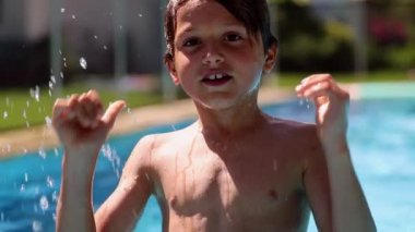 Happy young boy enjoying swimming pool water. Child plunging backwards holding breath