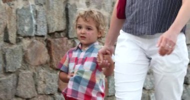 Mom holding child boy hands walking