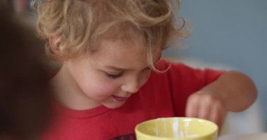 Child boy wiping table with napkin cleaning stain