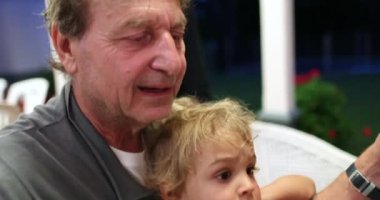 Toddler on grandpa lap
