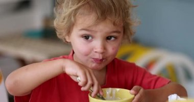 toddler child boy eating yogurt for breakfast morning