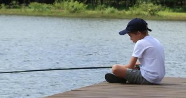 Child outdoors at lake fishing outside in nature