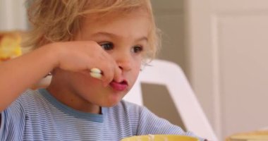 Portrait of baby boy eating yogurt , candid and casual