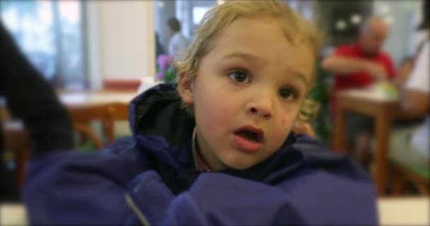 Μικρό Αγόρι Που Φοράει Αδιάβροχο Και Ξεκουράζεται Στο Εστιατόριο — Αρχείο Βίντεο