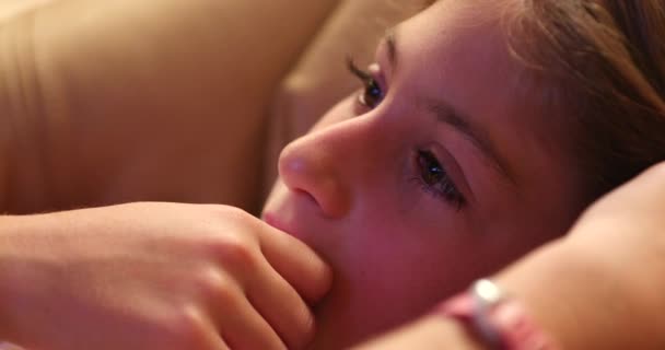小女孩面对着看电影直率真实的生活女孩凝视着银幕 — 图库视频影像