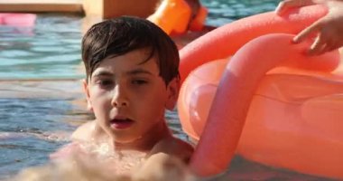 Yüzme havuzundaki genç çocuk samimi ve sıradan