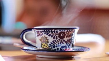 Cup of tea with smoke coming out, close-up of warm tea