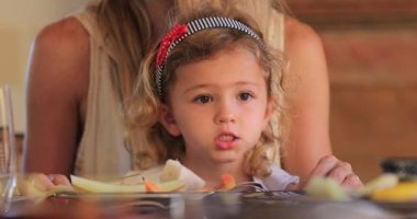 Portrait of thoughtful little girl thinking seated on mother lap