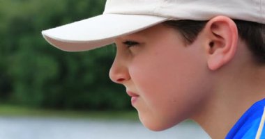 Mesafeye bakıp hayatı düşünen düşünceli genç bir çocuğun profili.