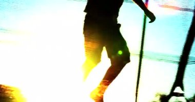 Güneş ışığında trambolinde zıplayan çocukların silueti.