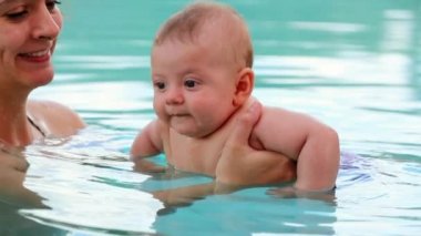 Happy baby boy at the swimming pool smiling to camera