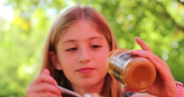 Küçük kız kendine tatlı tatlı tatlı ikram ediyor.