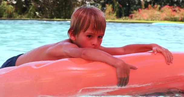 膨脹可能なマットレスの中に保持しているスイミングプールで男の子 — ストック動画