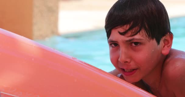 インフレータブルマットレスの上にあるスイミングプールで遊んでいる子供の男の子 — ストック動画