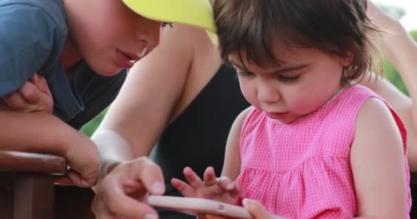 Niña Sosteniendo Dispositivo Teléfono Inteligente Niños Mirando Pantalla Madre Presionando — Vídeos de Stock