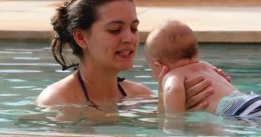 Mother and newborn baby at swimming pool water interaction