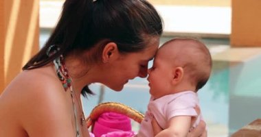 Mother cuddling with newborn baby outside