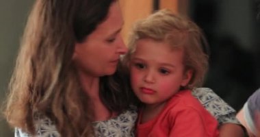 Mother embracing upset toddler boy candid and authentic love affection and family care