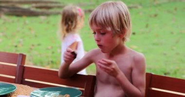 Kurabiye yiyen yakışıklı sarışın genç. Açık hava ve açık hava.