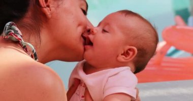 Newborn baby being kissed by mom