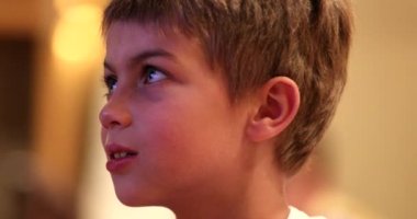 Küçük çocuk, samimi ve özgün bir şekilde gülümseyen bir film izlerken tepki veriyor.