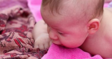 Newborn baby lying on the ground learning about the world outdoors