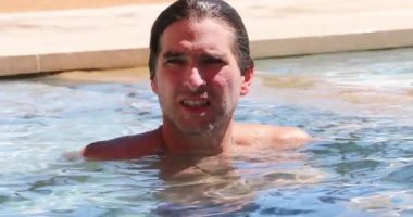 Havuz suyunda samimi yakışıklı bir adam.