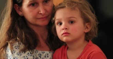 Düşünceli düşünceli bir çocuk ve annesi samimi aile oturma odasında.