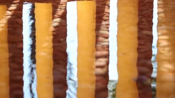 Orange Pillars Reflected Water Surface — Stockvideo