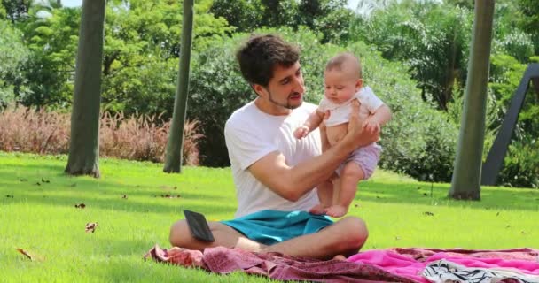 在公园外面的大自然里抱着幼儿的父亲 — 图库视频影像