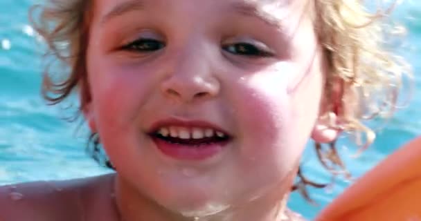 幼児はプールで膨脹可能な腕を着て — ストック動画